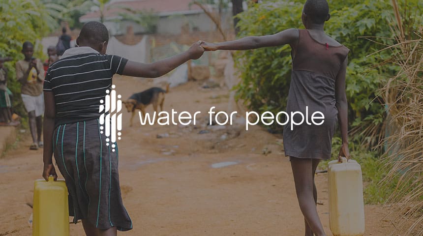 Two women carrying a water bucket