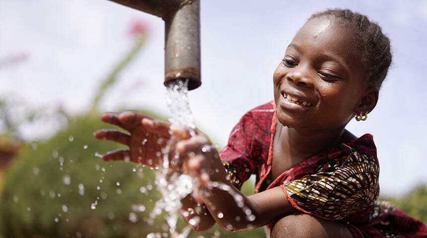child washing hands in pipewater