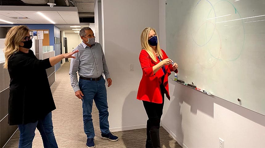 Team looking at whiteboard in office