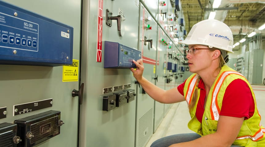 female engineer in hardhat at an instrument panel