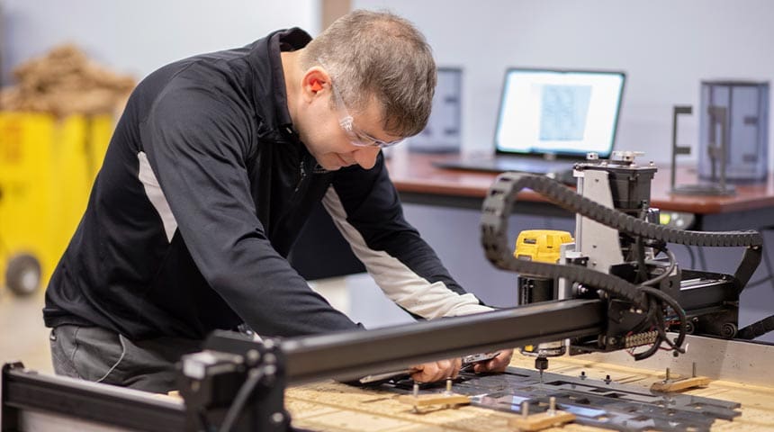 Man in lab usitng cutting machine