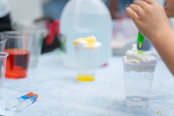 Child using food coloring on foam at a Carollo Cares STEM event