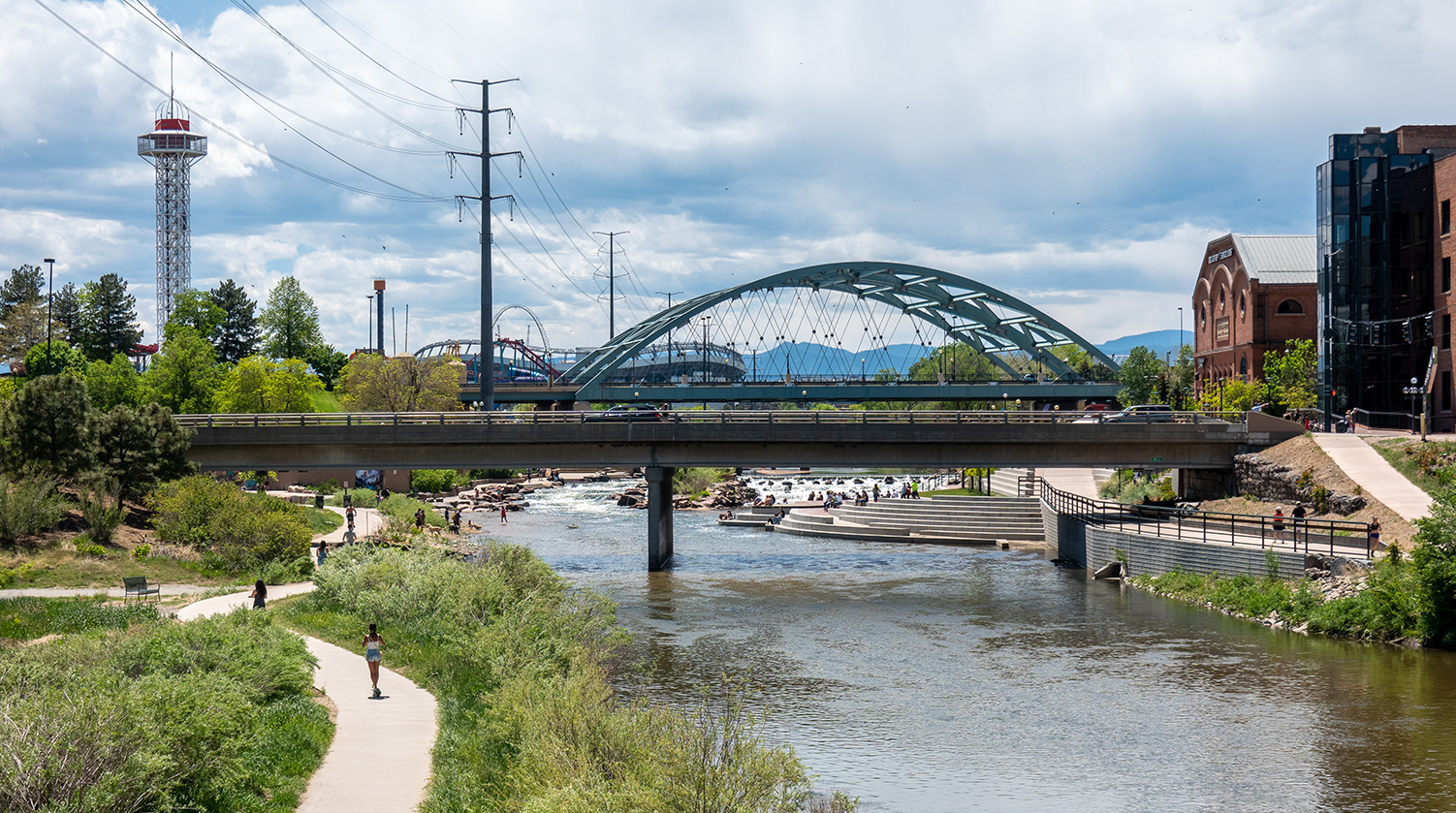 photo of a bridge over a small river with people running on a path along the water that represents Carollo's Resilience and Sustainability practice.